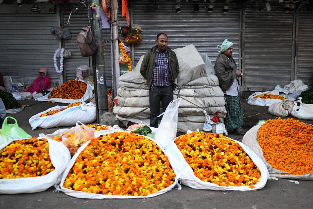 Flower vendors wait for customers along a road in the old quarters of Delhi, India, on Dec. 11, 2025. (Arun Sankar/AFP via Getty Images)