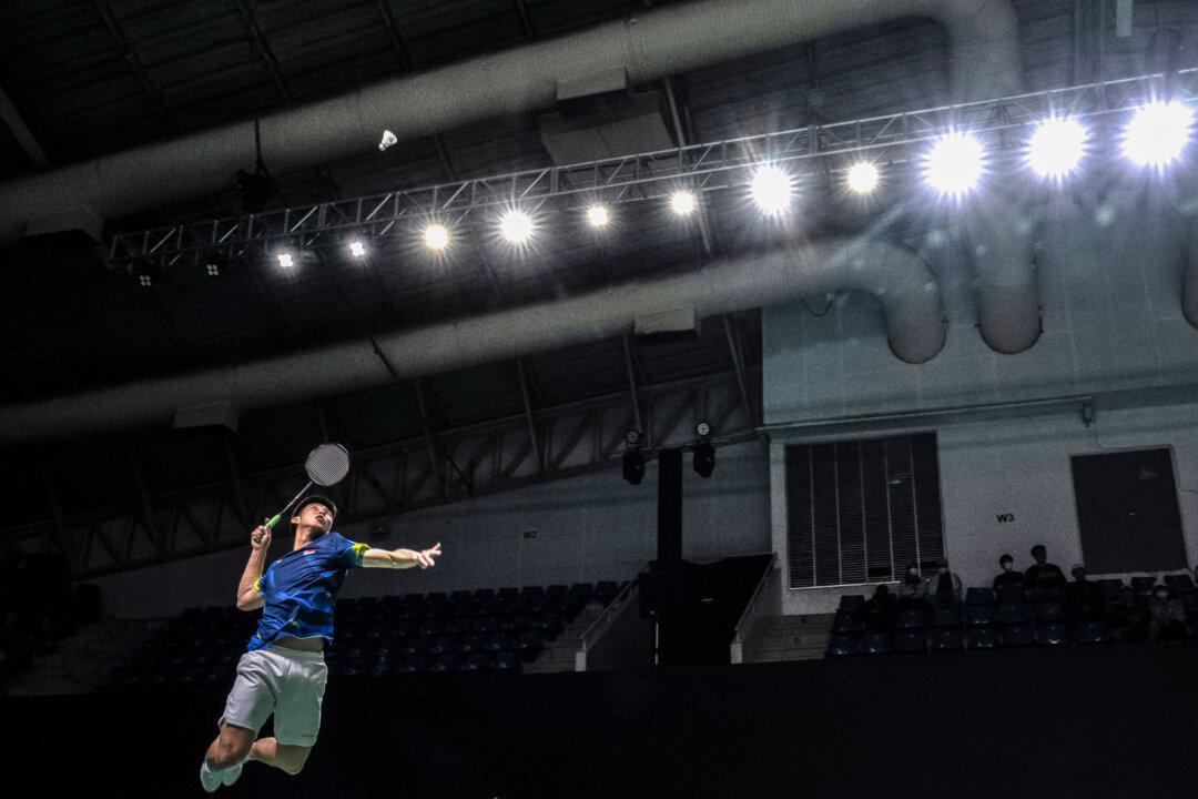 Singapore's Loh Kean Yew hits a return to Philippines' Jewel Angelo Albo in their men's single badminton match during the 33rd Southeast Asian Games (SEA Games) at Thammasat Rangsit in Pathum Thani near Bangkok, Thailand, on Dec. 11, 2025. (Chanakarn Laosarakham/AFP via Getty Images)