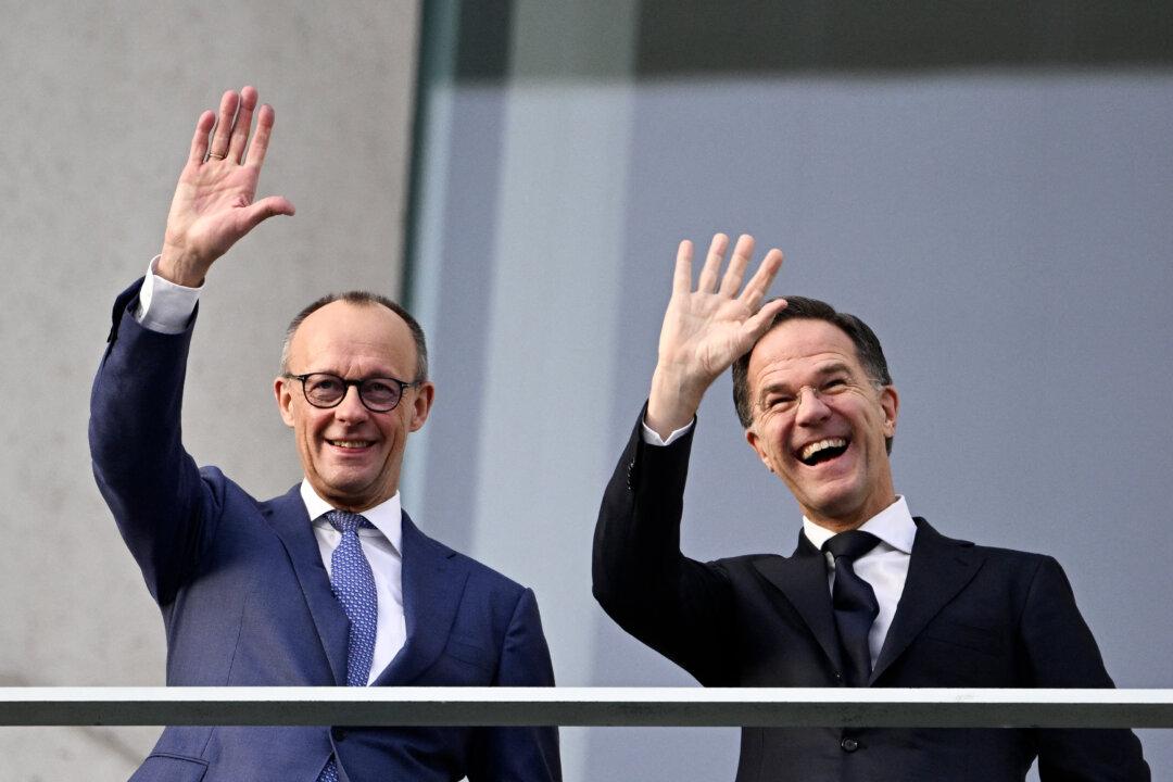 German Chancellor Friedrich Merz and NATO General Secretary Mark Rutte wave from the balcony of the Chancellery before the start of talks in Berlin, on Dec. 11, 2025. (Tobias Schwarz/AFP via Getty Images)