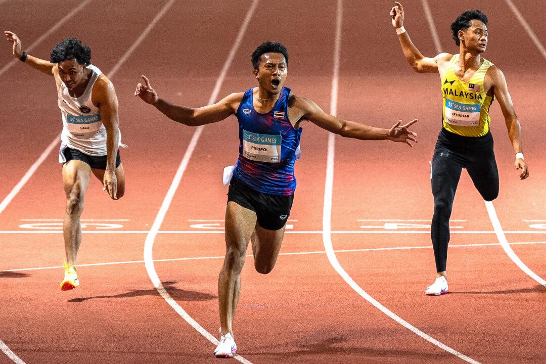 Thailand's Puripol Boonson (C) celebrates as he crosses the finish line next to Indonesia's Lalu Muhammad Zohri (L) and Malaysia's Danish Iftikhar Muhammad Roslee (R) in the men's 100m final of the athletics event during the 33rd Southeast Asian Games (SEA Games) at the Suphachalasai National Stadium in Bangkok, Thailand, on Dec. 11, 2025. (Chanakarn Laosarakham/AFP via Getty Images)