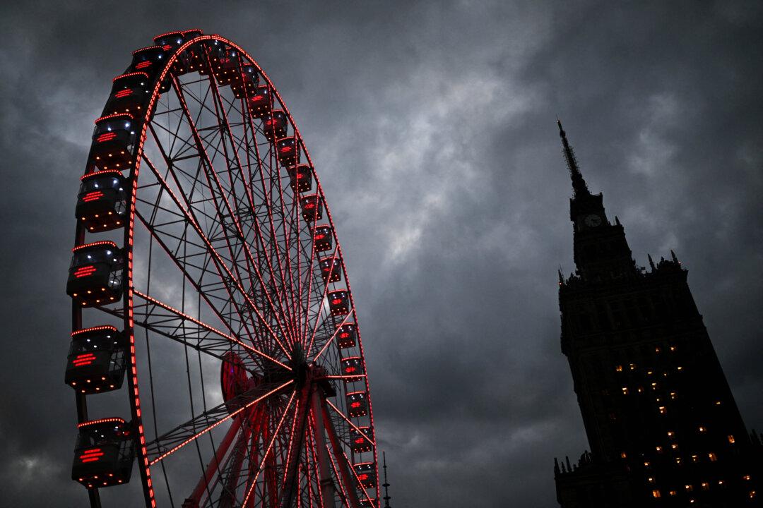 People ride a Ferris wheel in front of the Palace of Culture and Science at the Christmas market in Warsaw, Poland, on Dec. 11, 2025. (Sergei Gapon/AFP via Getty Images)