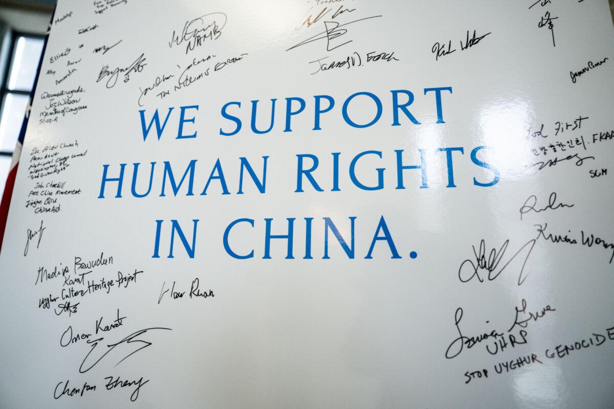 People sign a board supporting human rights in China during the China Human Rights Advocacy Fair at the Rayburn House Office Building on Capitol Hill in Washington on Dec. 10, 2025. (Madalina Kilroy/The Epoch Times)