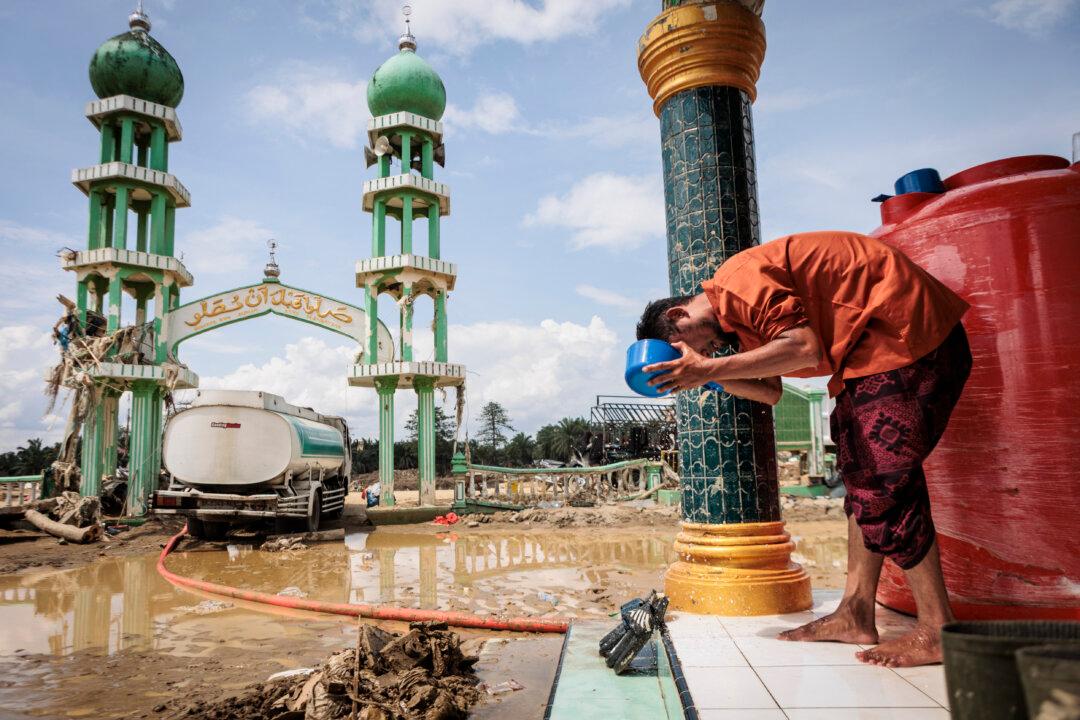 A Muslim man washes his face before attending Friday prayers at Al Ihsan Mosque, which was partially damaged by flooding, in Aceh Tamiang, North Sumatra, on Dec. 12, 2025. Tropical storms and monsoon rains have pummelled Southeast and South Asia this month, triggering landslides and flash floods from the rainforests of Sumatra to highland plantations in Sri Lanka—and more rains are predicted. (Aditya Aji/AFP via Getty Images)