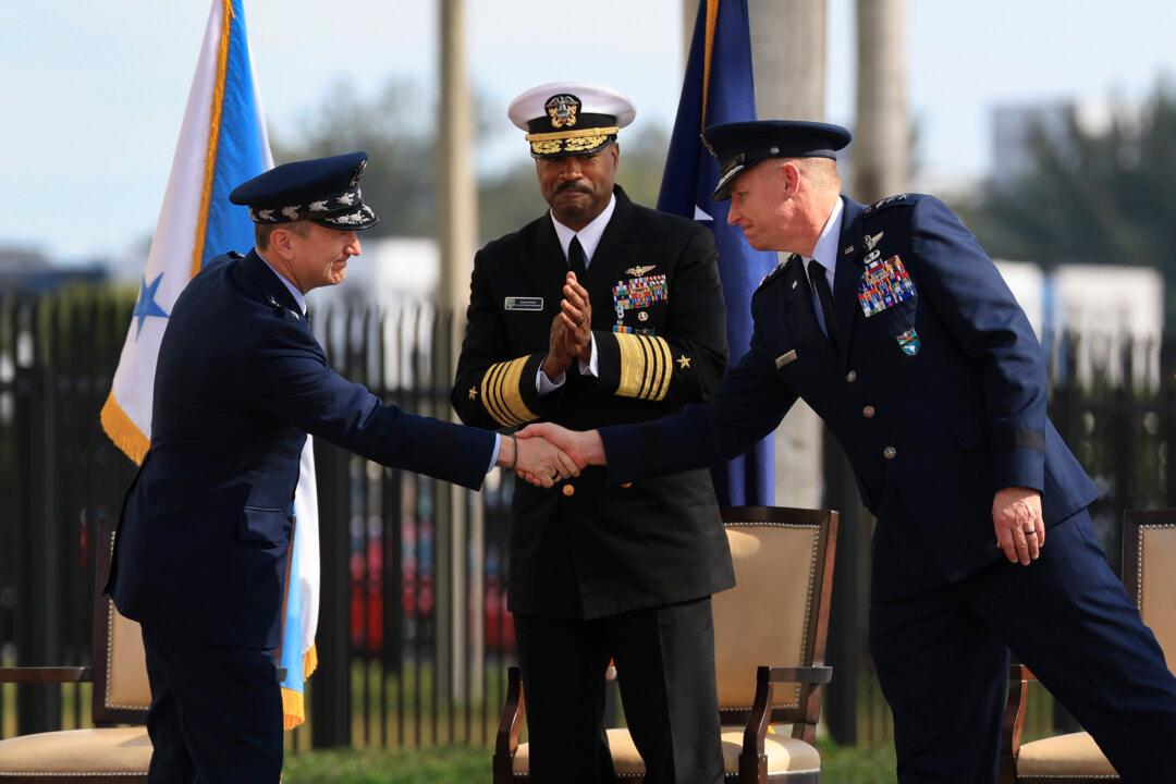 Chairman of the Joint Chiefs of Staff Gen. Dan Caine (L) shakes hands with Air Force Lt. Gen. Evan L. Pettus (R) as Navy Adm. Alvin Holsey (C) looks on during a relinquish of Command and Retirement Ceremony at the U.S. Southern Command headquarters in Doral, Fla., on Dec. 12, 2025. Navy Adm. Alvin Holsey stepped down as commander of U.S. Southern Command and will retire after more than 37 years of service in the U.S. Navy. (Joe Raedle/Getty Images)
