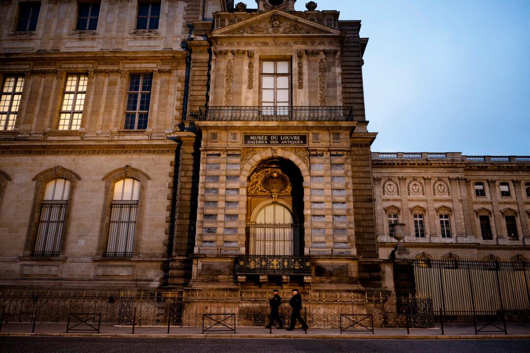 Police officers walk next to posts newly installed on the sidewalk along the Louvre Museum, on Quai Francois Mitterrand, in Paris on Dec. 12, 2025, a few weeks after thieves used a furniture lift to break into the museum. Robbers broke into the Louvre and fled with jewelry on the morning of Oct. 19, after arriving on a scooter armed with small chainsaws and using a goods lift to reach the room they were targeting. (Anna Kurth/AFP via Getty Images)