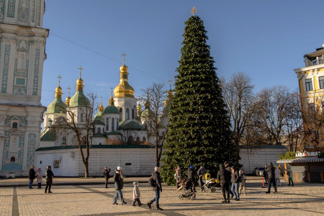 Local residents walk near Kyiv's main Christmas tree on the St. Sophia Square in Kyiv, Ukraine, on Dec. 13, 2025. (Roman Pilipey/AFP via Getty Images)