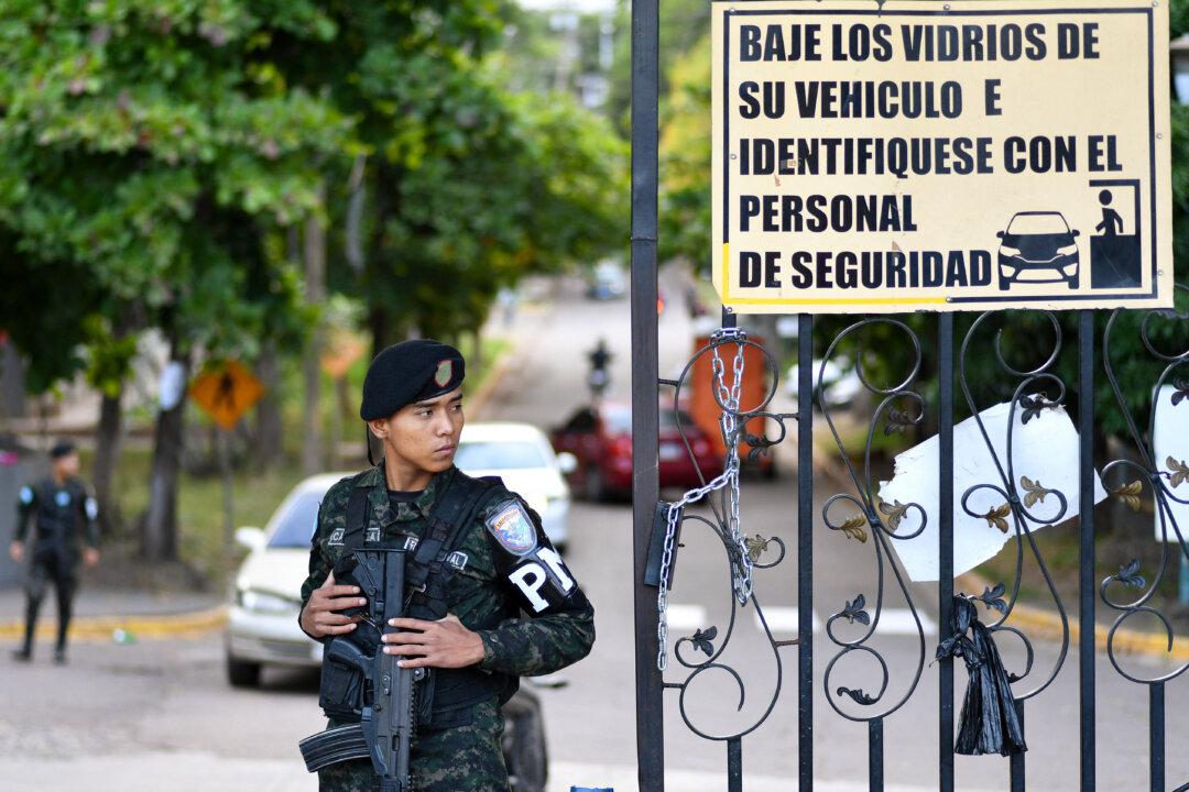 A member of the military police stands guard at the entrance of the Professional Formation National Institute headquarters, where the electoral material of the last presidential election is being counted, in Tegucigalpa, Honduras, on Dec. 13, 2025. (Orlando Sierra/AFP via Getty Images)