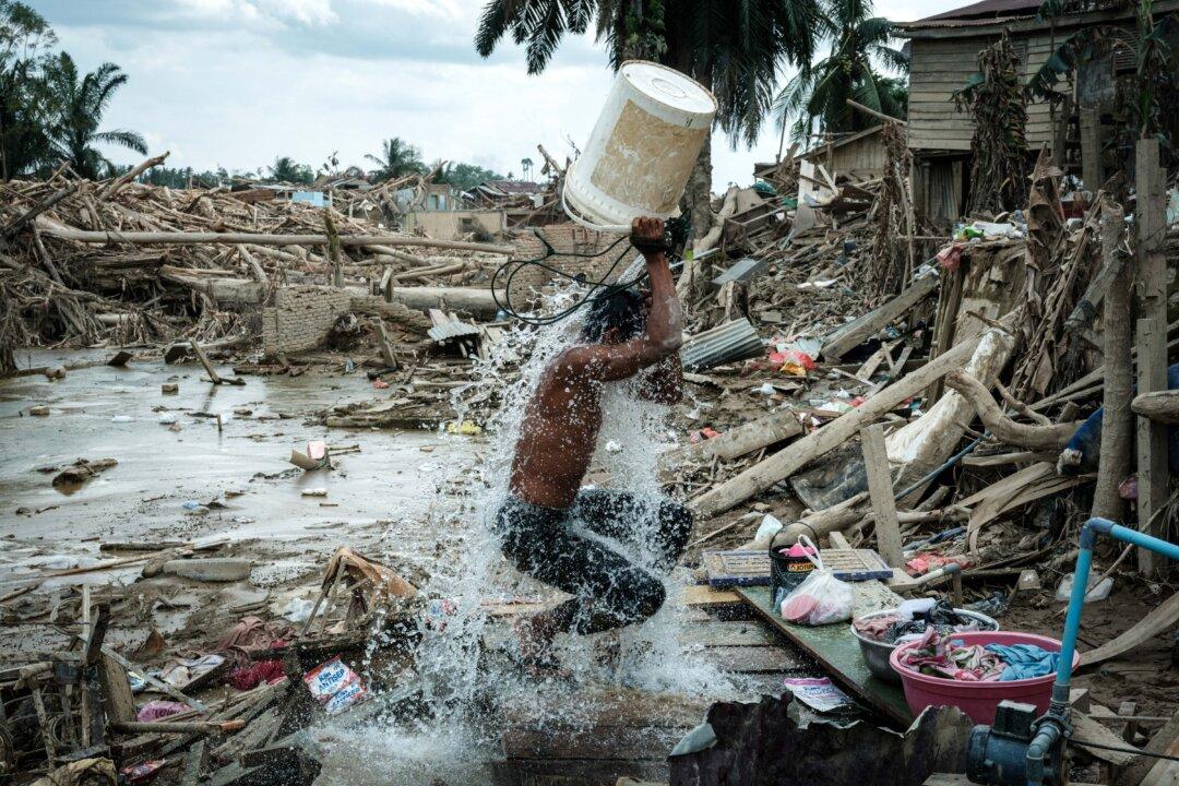 A man washes off mud from his body in an area affected by a flash flood in Aceh Tamiang, Northern Sumatra, Indonesia, on Dec. 13, 2025. (Yasuyoshi Chiba/AFP via Getty Images)