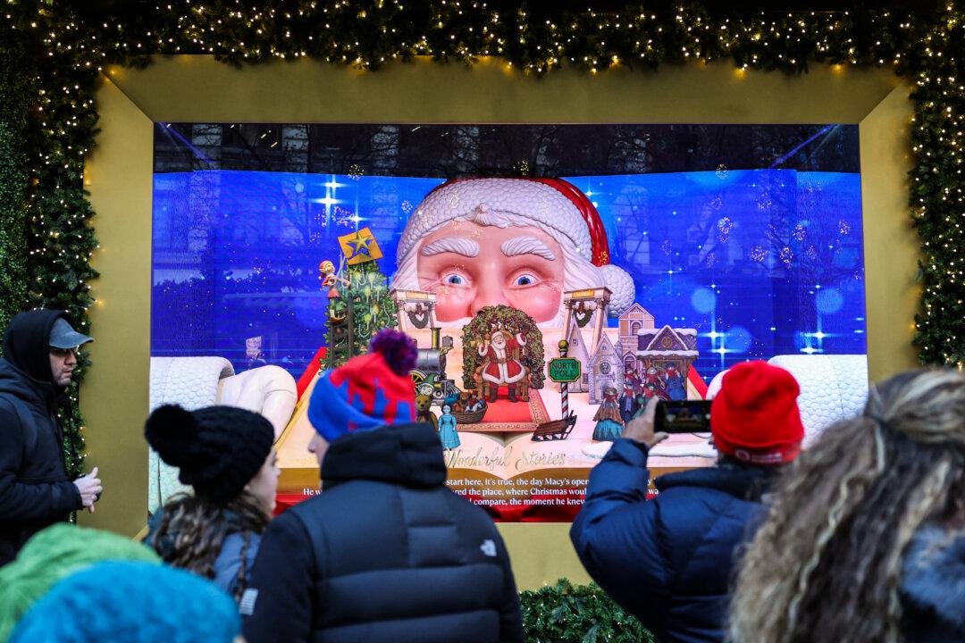 People look at a window decorated for Christmas in New York City on Dec. 11, 2025. (Angela Weiss/AFP via Getty Images)