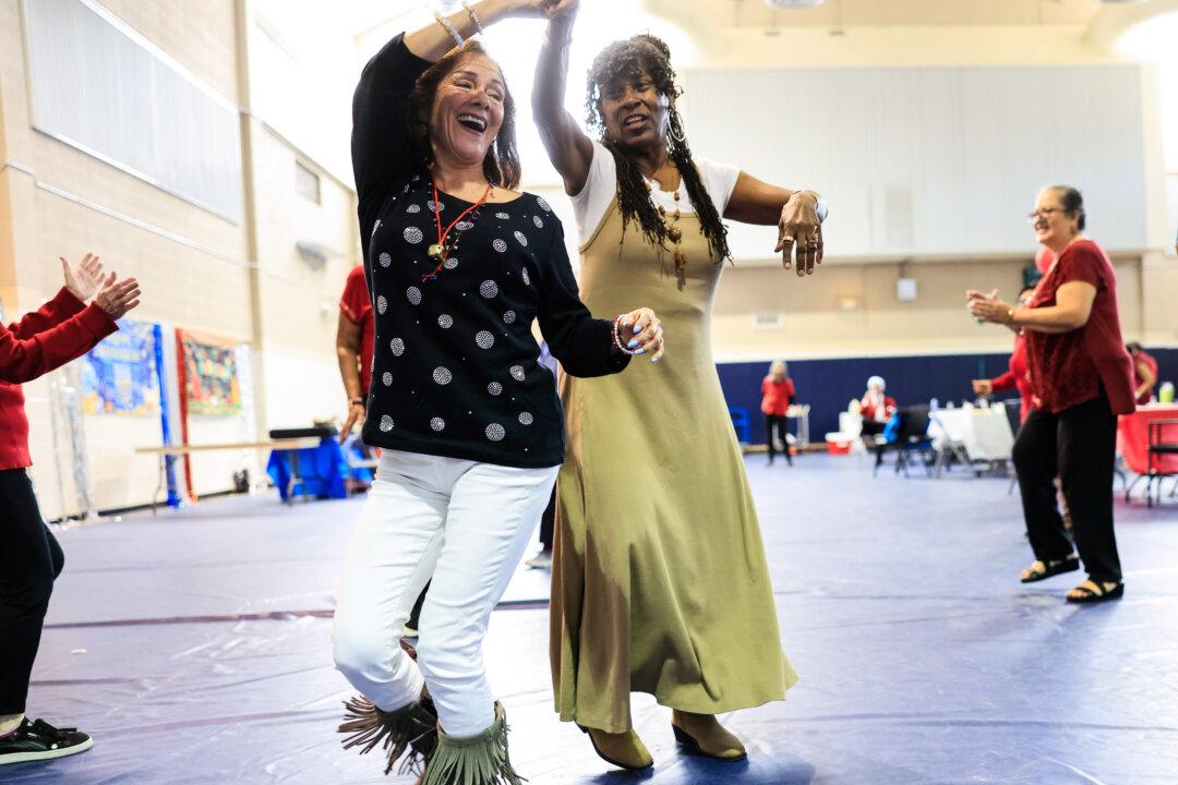 Beneigh McNeely (R), who remains displaced from her home by the Eaton Fire, dances at the Altadena Senior Center holiday party in Altadena, Calif., on Dec. 8, 2025. The Altadena Senior Center was destroyed in the Eaton Fire, but the group continues to meet at Altadena’s Satellite Senior Center location. (Mario Tama/Getty Images)
