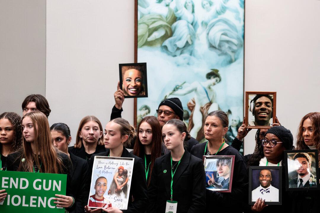 Survivors and family members of gun violence and their advocates hold photographs of victims during a news conference on the 13th anniversary of the Sandy Hook Elementary School shooting on Capitol Hill in Washington on Dec. 11, 2025. Members of the Connecticut Congressional delegation joined the news conference to push for more gun control legislation. (Heather Diehl/Getty Images)