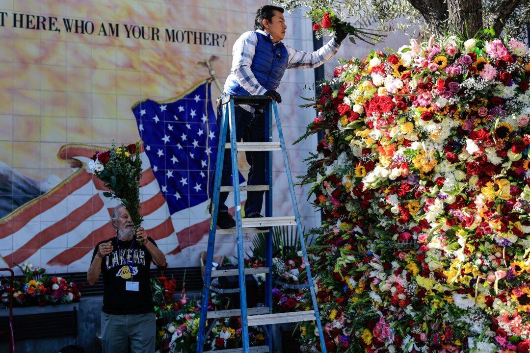 A worker places flowers left by the faithful outside a church on the feast of Our Lady of Guadalupe, the patron saint of Mexico, in Los Angeles on Dec. 12, 2025. The annual celebration honors the apparition of the Virgin Mary in Tepeyac, Mexico, in December 1531 and has been marked by Mexican Catholics for centuries. (Mario Tama/Getty Images)