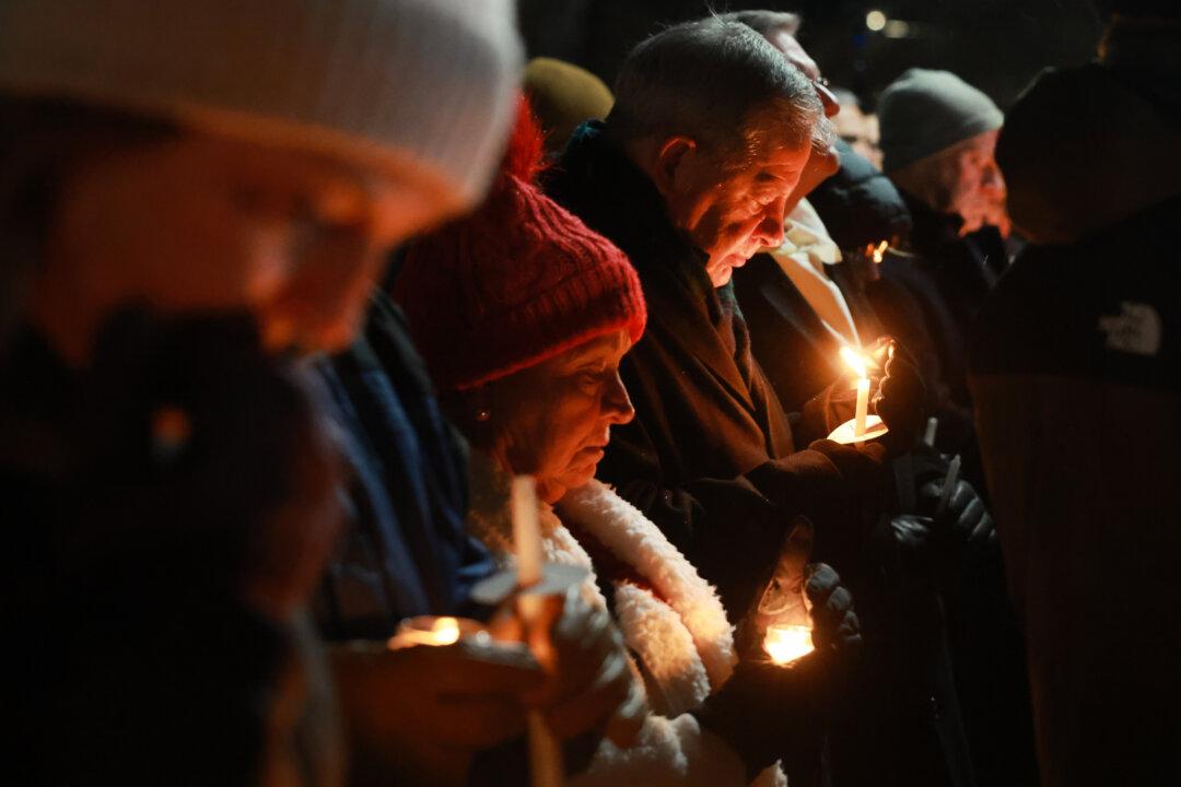 People gather for a candlelight vigil following a mass shooting the day before at Brown University that left two people dead and nine others injured, in Providence, R.I., on Dec. 14, 2025. A person of interest in the shooting was detained overnight at a hotel in a nearby community following a manhunt across the university and the greater Providence area. (Spencer Platt/Getty Images)
