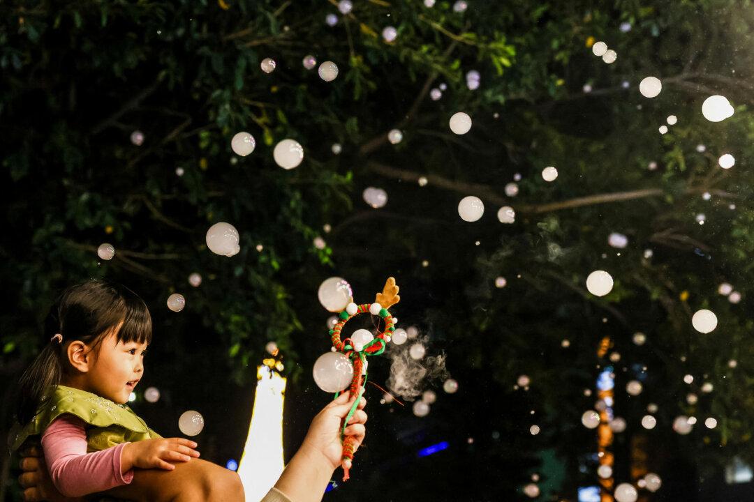 A child enjoys artificial snowfall at a street decorated with lights ahead of the Christmas festival in Pingtung, Taiwan, on Dec. 22, 2025. (I-Hwa Cheng/AFP via Getty Images)