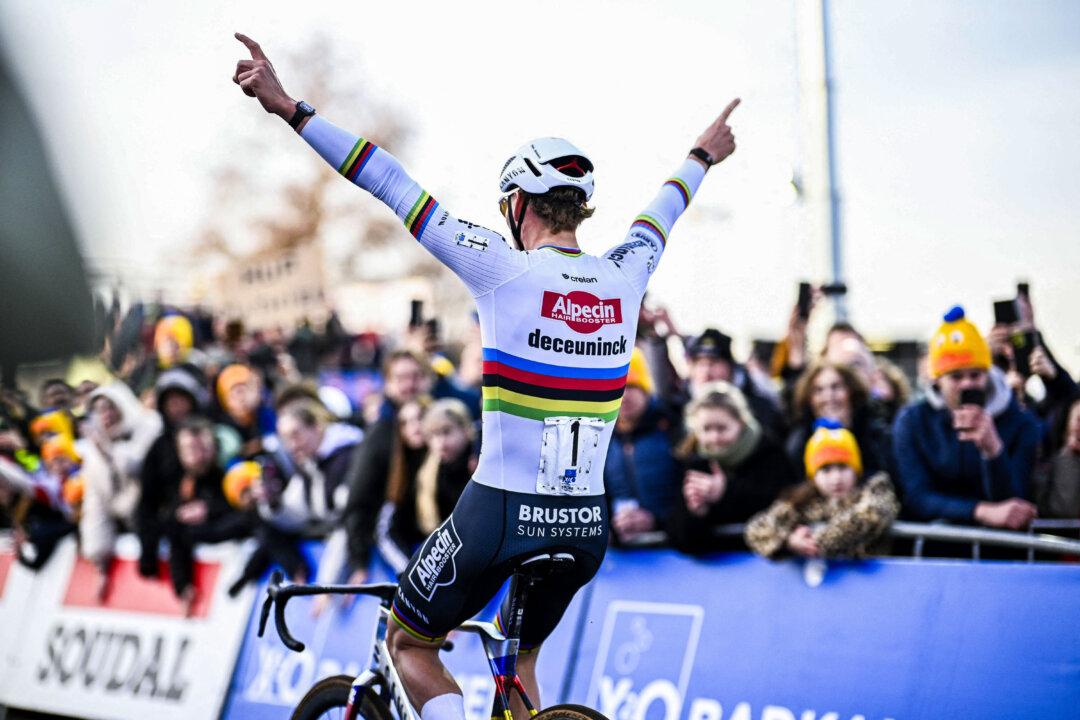 Alpecin-Deceuninck's Dutch cyclist Mathieu Van Der Poel celebrates as he crosses the finish line in the men's elite race of the “Plage Cross” cyclocross event in Hofstade, Belgium, on Dec. 22, 2025. (Jasper Jacobs/Belga/AFP via Getty Images)