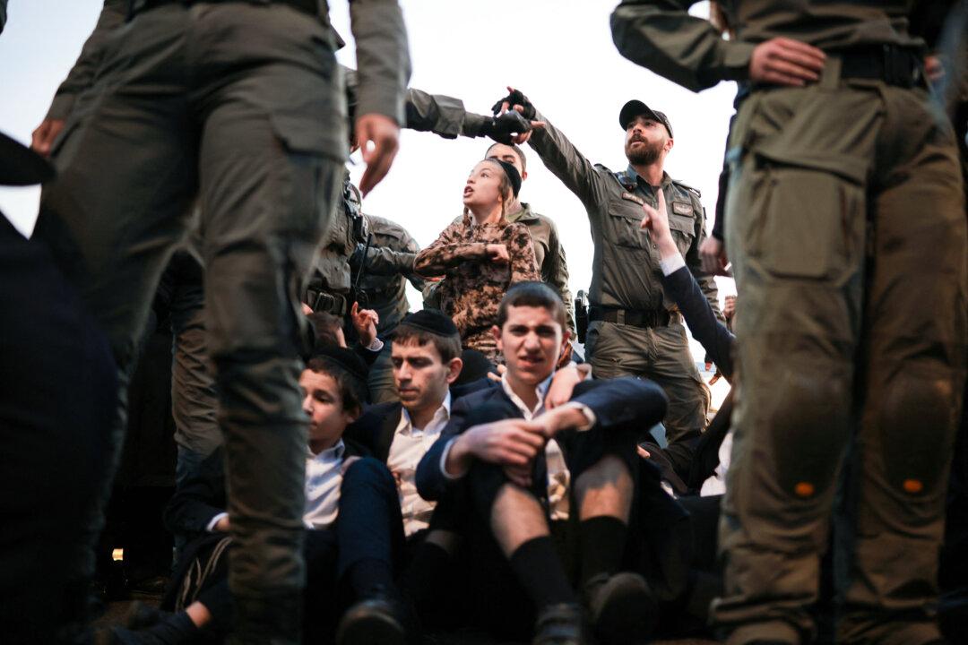 Israeli security forces disperse ultra-Orthodox Jewish men blocking a road during a protest against conscription into the Israeli army in Bnei Brak near Tel Aviv on Dec. 22, 2025. (Ilia Yefimovich/AFP via Getty Images)