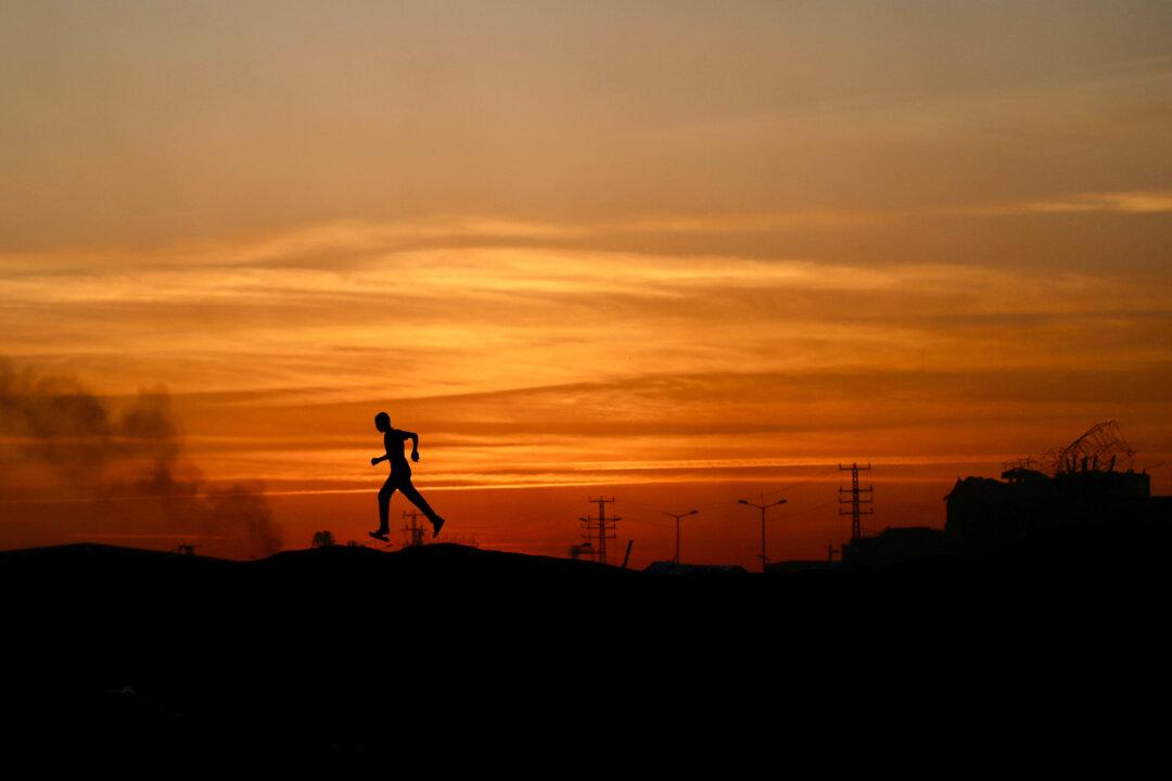A Palestinian youth is silhouetted by the setting sun at the Nuseirat camp for the displaced in the central Gaza Strip on Dec. 22, 2025. (Eyad Baba/AFP via Getty Images)