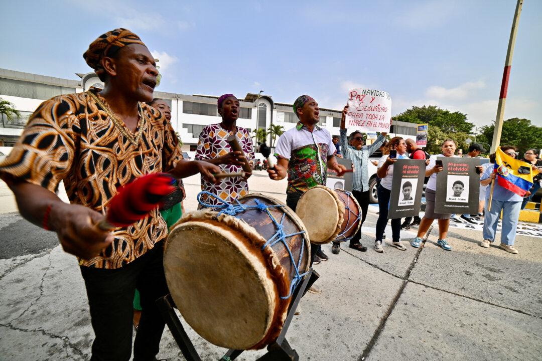 Relatives and members of human rights organizations play drums and hold signs saying “Christmas should be peace and security for the world's children” outside a court in Guayaquil, Ecuador, on Dec. 22, 2025, during a sentencing hearing on the soldiers involved in the forced disappearance of four boys last year. Eleven Ecuadorian soldiers were each sentenced to nearly 35 years in prison for the forced disappearance of the boys, ages 11 to 15, whose bodies were found beaten and burned, the Attorney General's Office said. (Marcos Pin/AFP via Getty Images)