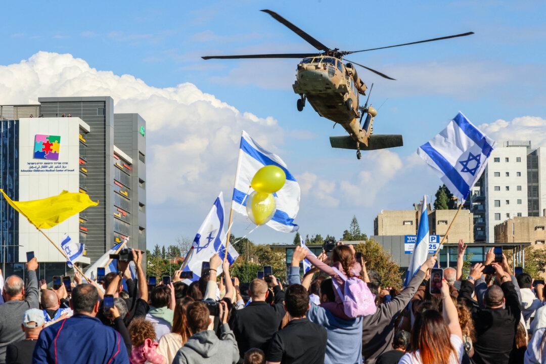 People wave Israeli national flags as a military helicopter transporting four newly-released Israeli hostages lands at the Beilinson Hospital in Petah Tikva, Israel, on Jan. 25, 2025. Hamas terrorists abducted the four soldiers on Oct. 7, 2023, while the soldiers were stationed near the Gaza border. They were released after more than 15 months in captivity. (Yossi Zamir/AFP via Getty Images)