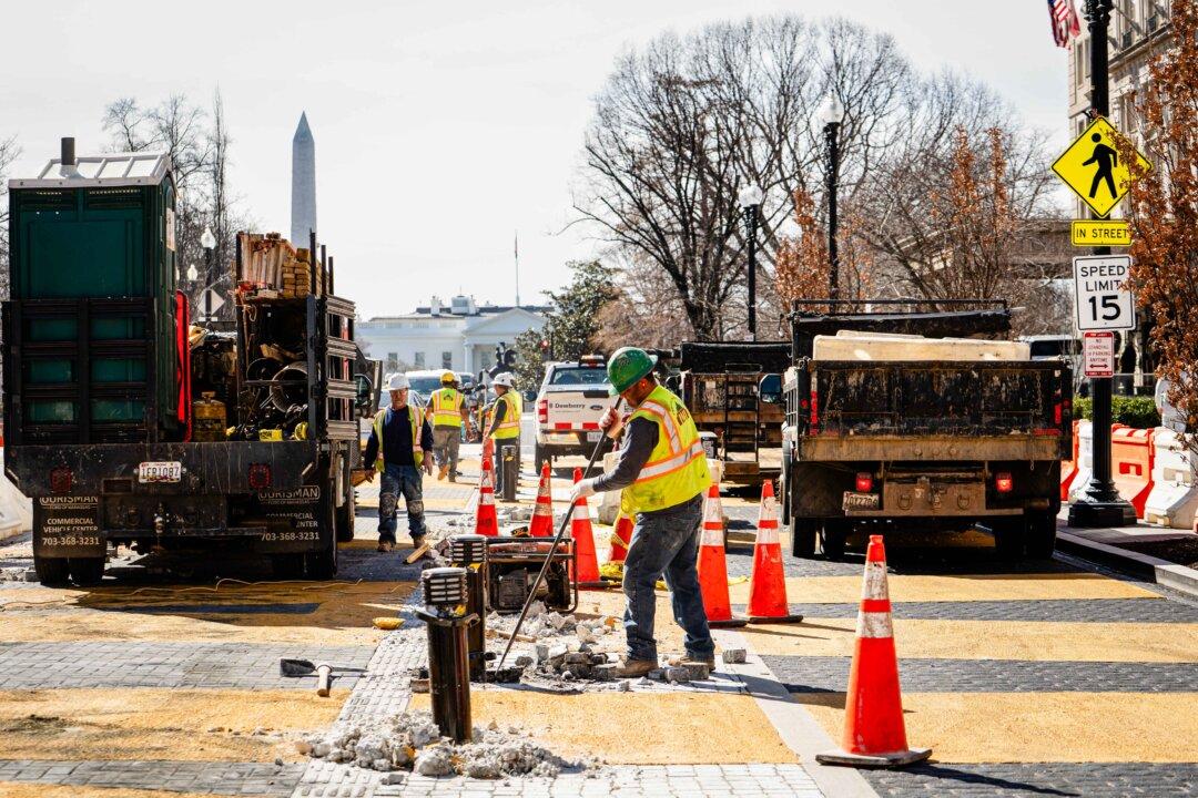 Construction workers demolish the Black Lives Matter lettering in the plaza near the White House on March 10, 2025. (Madalina Vasiliu/The Epoch Times)