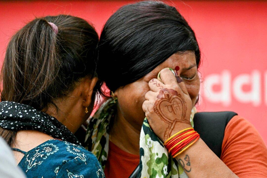 Women mourn as the bodies of their relatives, killed the previous day after Air India flight 171 crashed in a residential area, are taken out of a hospital mortuary in Ahmedabad, India, on June 13, 2025. Rescue teams with sniffer dogs combed the crash site of the London-bound passenger jet, which ploughed into a residential area of Ahmedabad, killing at least 265 people on board and on the ground. (Punit Paranjpe/AFP via Getty Images)