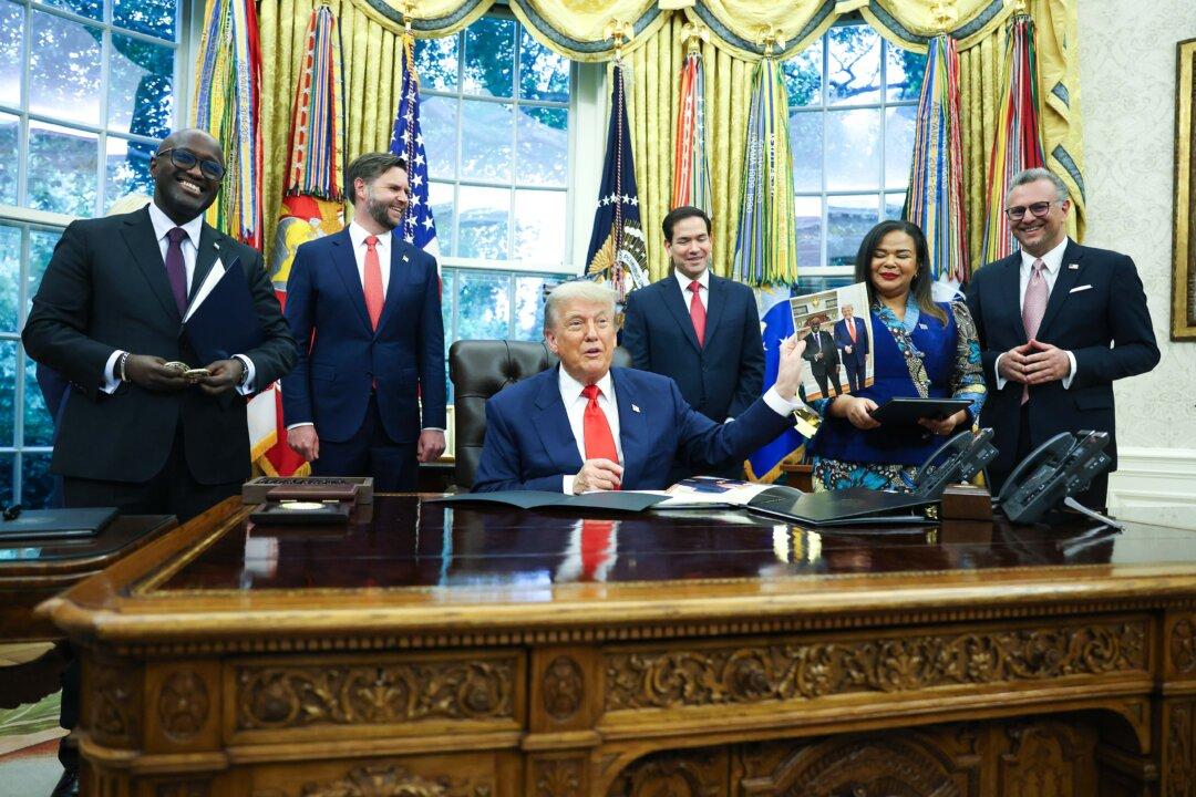 U.S. President Donald Trump holds a photo as he meets with Minister of Foreign Affairs and Cooperation of Rwanda Olivier Nduhungirehe and the Foreign Minister of the Democratic Republic of the Congo Thérèse Kayikwamba Wagner in the Oval Office on June 27, 2025. The meeting took place as a peace agreement brokered by the White House, which hopes to end a conflict in eastern Democratic Republic of Congo, was signed by officials of the two African nations. The leaders were also joined by Vice President JD Vance, Secretary of State Marco Rubio, and Massad Boulos, senior Trump adviser. (Joe Raedle/Getty Images)
