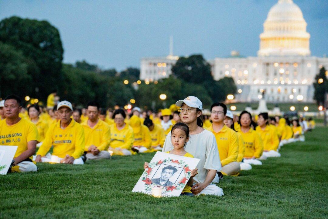 Falun Dafa practitioners take part in a candlelight vigil commemorating the spiritual discipline's practitioners who were persecuted to death by the Chinese Communist Party in China, in Washington on July 17, 2025. (Samira Bouaou/The Epoch Times)