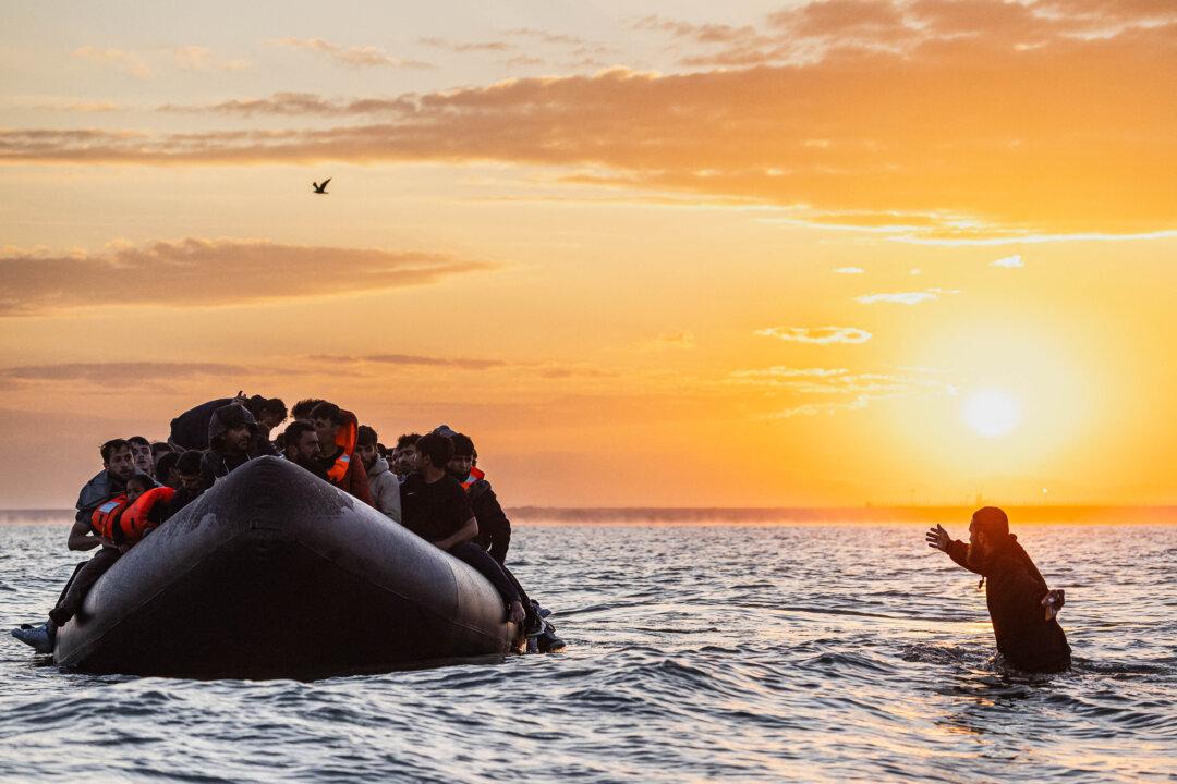 A migrant tries to board a smuggler's inflatable dinghy in an attempt to cross the English Channel off the beach of Gravelines, northern France, on July 29, 2025. (Sameer Al-Doumy/AFP via Getty Images)