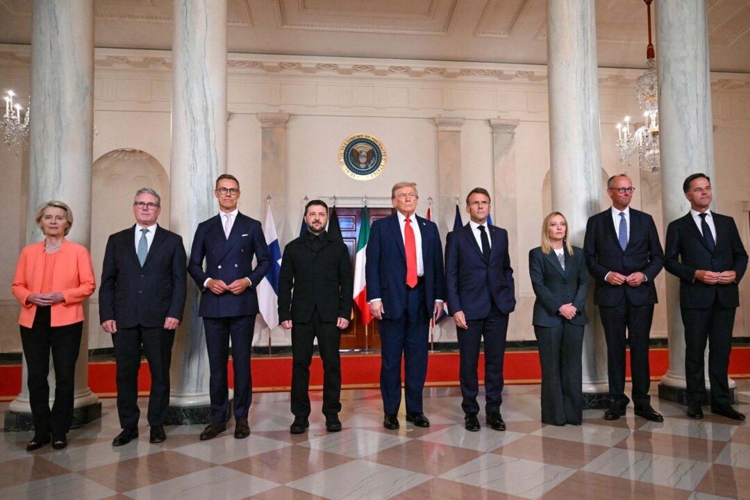 (L-R) European Commission President Ursula von der Leyen, British Prime Minister Keir Starmer, Finnish President Alexander Stubb, Ukrainian President Volodymyr Zelenskyy, U.S. President Donald Trump, French President Emmanuel Macron, Italian Prime Minister Giorgia Meloni, German Chancellor Friedrich Merz, and NATO Secretary-General Mark Rutte pose for a photo in the Cross Hall of the White House on Aug. 18, 2025. The European leaders joined Zelenskyy in talks with Trump on Aug. 18 to try to find a way to end Russia's offensive. (Andrew Caballero-Reynolds/AFP via Getty Images)