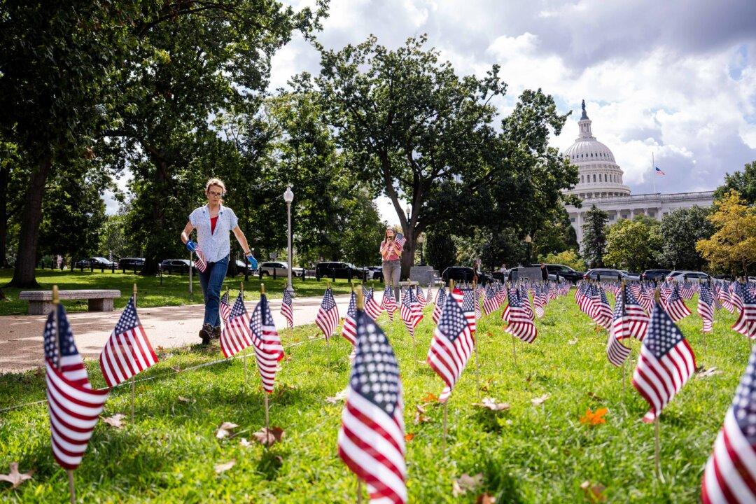 People place American flags to commemorate the 9/11 terrorist attacks in 2001, on Capitol Hill in Washington on Sept. 11, 2025. (Madalina Kilroy/The Epoch Times)