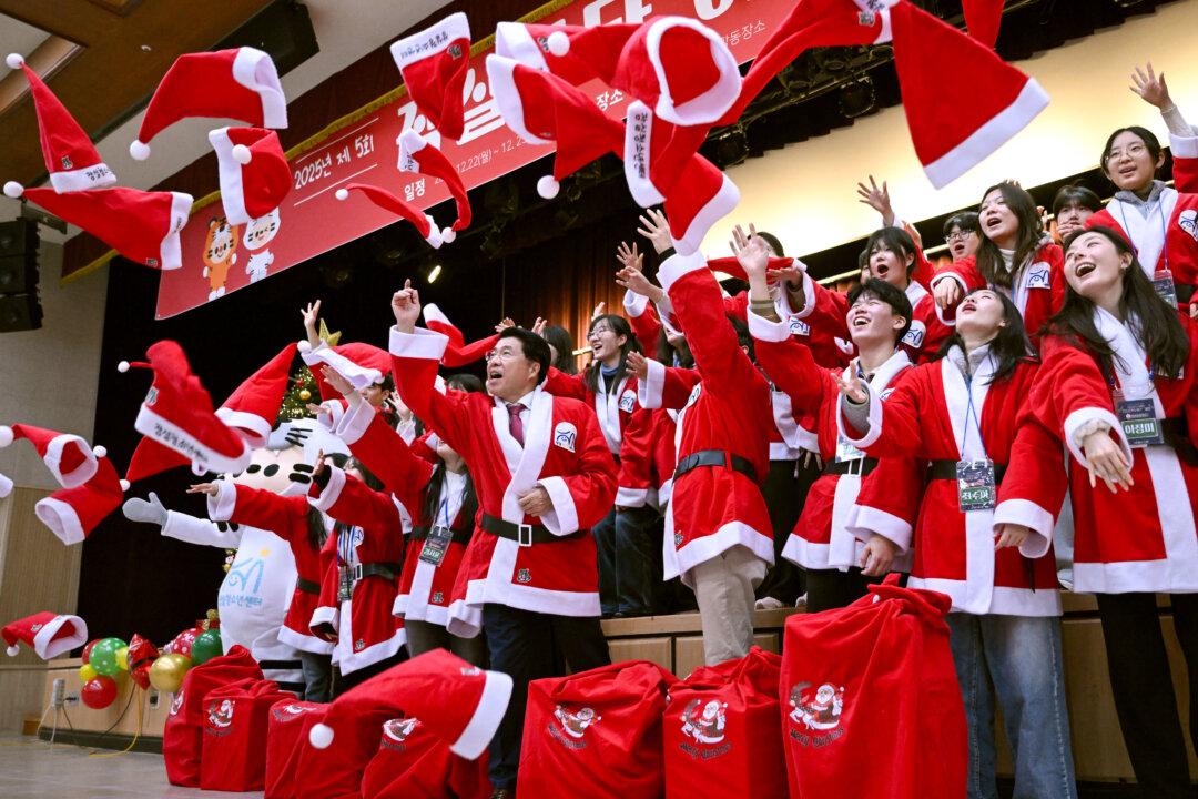 South Korean volunteers dressed as Santa Claus throw hats during a ceremony before the delivery of Christmas gifts for the underprivileged at Songpa District Office in Seoul on Dec. 23, 2025. (Jung Yeon-je/AFP via Getty Images)