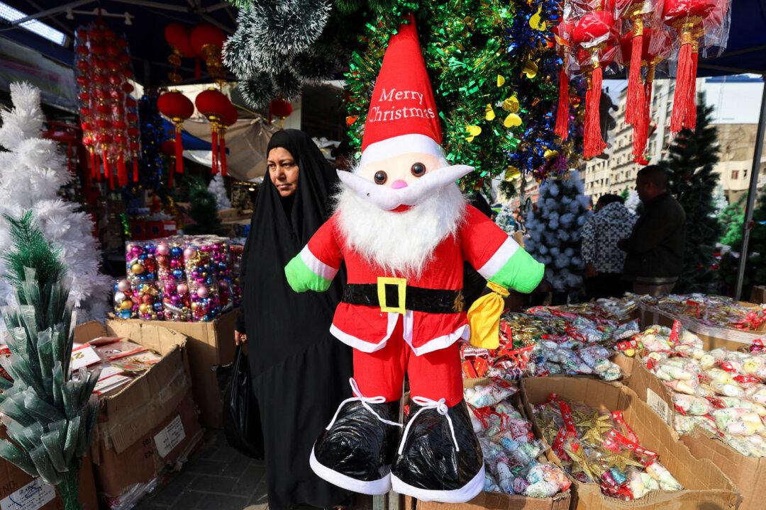 A Muslim woman passes stalls selling Christmas decorations at the Al-Shourja market in central Baghdad on Dec. 23, 2025. (Ahmad Al-Rubaye/AFP via Getty Images)
