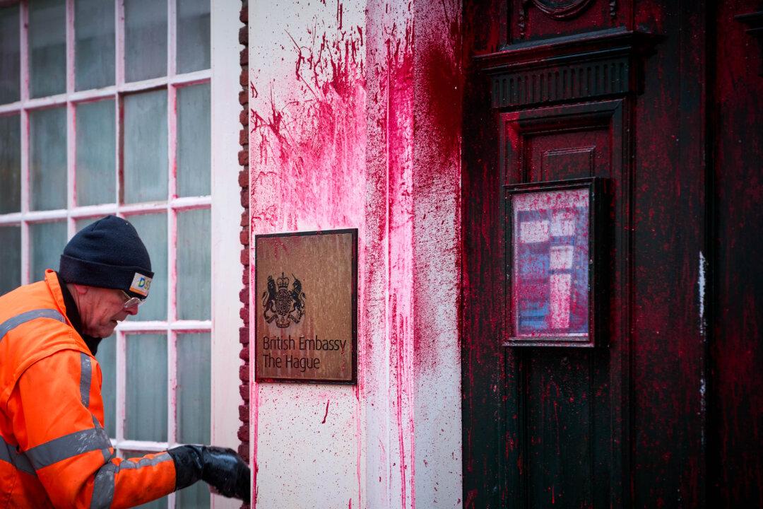 An employee cleans the facade of the British Embassy on Lange Voorhout in The Hague, Netherlands, on Dec. 23, 2025, after it was defaced with red paint. (Phil Nijhuis/ANP/AFP via Getty Images)