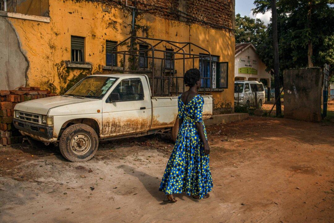 Everlyn Ayo, a survivor abducted by the Lord's Resistance Army, walks past a site she recalls using as a shelter during her night commutes, in Gulu, Uganda, on Sept. 4, 2025. The International Criminal Court will from Sept. 9 hear war crimes charges against the fugitive Ugandan warlord Joseph Kony, accused of spearheading a brutal reign of terror that resulted in the killing and abduction of tens of thousands. The “night commuters,” one of the emblematic features of the horrific insurgency that raged for years, were children who trekked through each dark night to stay in towns or shelters where they hoped they were less at risk of being kidnapped by Kony's army. (Stuart Tibaweswa/AFP via Getty Images)