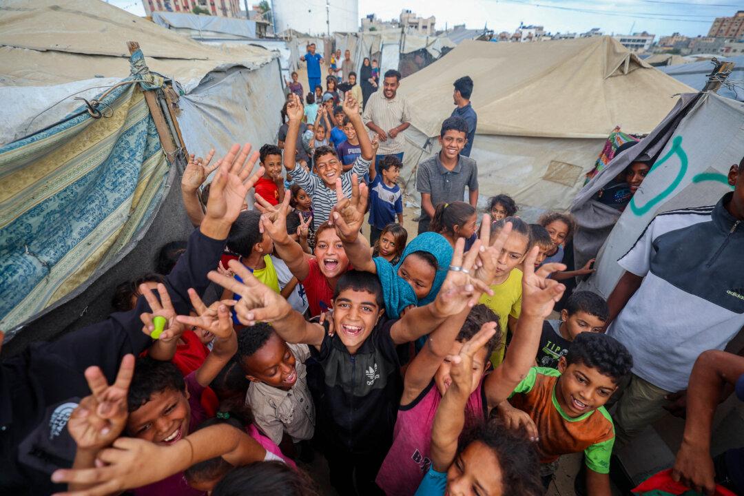 Palestinian children celebrate at a camp for displaced people in Nuseirat in the central Gaza Strip on Oct. 9, 2025. Israel and Hamas on October 9 agreed on a cease-fire deal that includes the release of the remaining living hostages held in Gaza. (Eyad Baba/AFP via Getty Images)