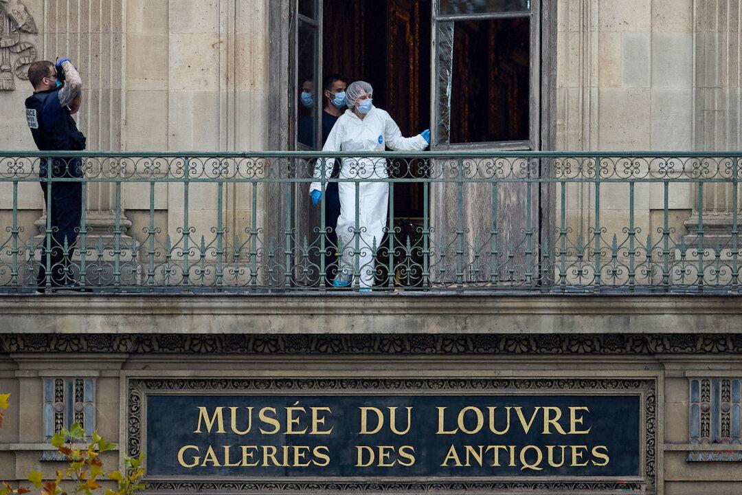 A French forensics officer examines the cut window and balcony of a gallery at the Louvre Museum, the scene of a robbery, in Paris on Oct. 19, 2025. (Kiran Ridley/Getty Images)