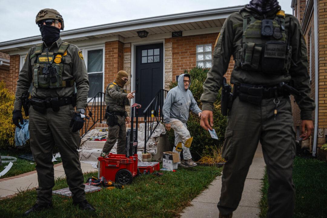 Federal agents, including Gregory Bovino, El Centro Sector's chief patrol agent for Customs and Border Protection, detain two men working on a home in the Edison Park neighborhood of Chicago on Oct. 31, 2025. One man was released after showing proof of citizenship, while the other was arrested, during the ongoing immigration enforcement surge across the Chicago area. (Jamie Kelter Davis/Getty Images)