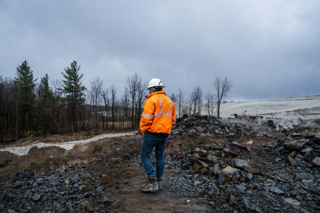 Empire State Mines General Manager Joel Rheault views a pit being excavated into the side of zinc mine (right) from atop a windblown ridge where Titan Mining Corporation is developing a graphite project near Gouverneur, N.Y., on Nov. 6, 2025. The century-old mine and mill in rural St. Lawrence County will be producing concentrates for U.S. manufacturers–now totally reliant on imports–by year's end. (Madalina Kilroy/The Epoch Times)