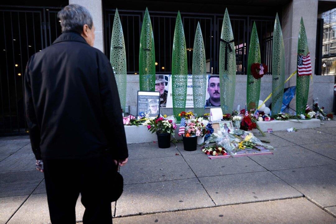 A man looks at a memorial for the shooting of two members of the National Guard in Washington on Dec. 1, 2025. Two National Guard troops, Staff Sgt. Andrew Wolfe and Specialist Sarah Beckstrom were shot on Nov. 26 near the White House in what authorities described as a targeted attack by an Afghan migrant who previously worked with the U.S. military in Afghanistan, a case now being investigated as a terrorism attack. (Brendan Smialowski/AFP via Getty Images)