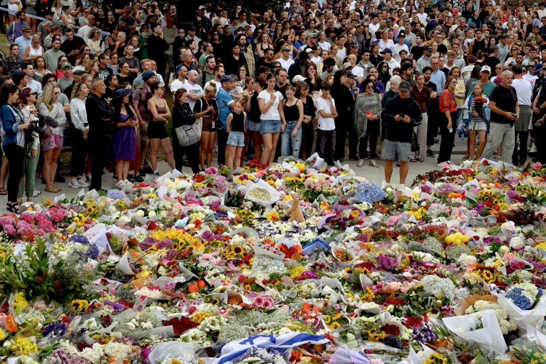 Mourners gather by floral tributes at the Bondi Pavilion in memory of the victims of a shooting at Bondi Beach, in Sydney on Dec. 15, 2025. A father and son opened fire on a Jewish festival at AustraliaÕs Bondi Beach, killing 15 people, including a child, authorities said on December 15, denouncing the attack as anti-Semitic terrorism. (Saeed Khan/AFP via Getty Images)