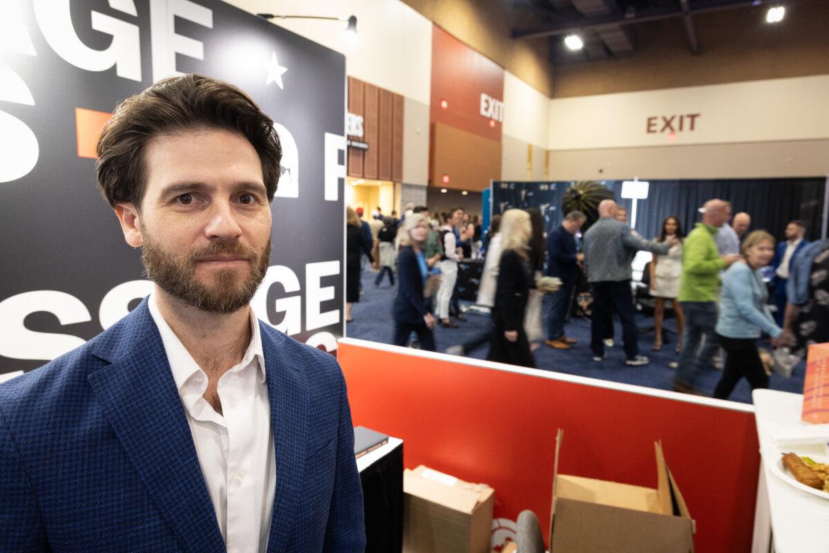 Jonathan Keeperman stands in the exhibit area of Turning Point USA's AmericaFest in Phoenix on Dec. 20, 2025. (John Fredricks/The Epoch Times)