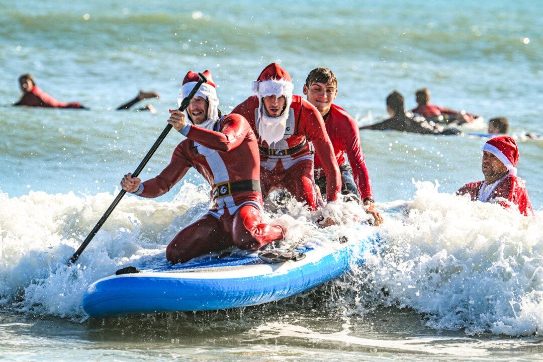 Surfers and spectators participate in the 17th annual “Surfing Santas” event in Cocoa Beach, Fla., on Dec. 24, 2025. (Giorgio Viera/AFP via Getty Images)