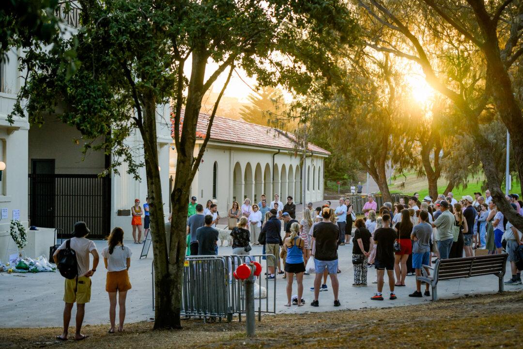 People gather during a reading of the names of the victims of the Bondi mass shooting at Bondi Pavilion at Bondi Beach in Sydney on Dec. 24, 2025. Australians typically flock to the sea over Christmas and New Year, with the period taking on a special significance this year in the wake of the shooting. (George Chan/Getty Images)