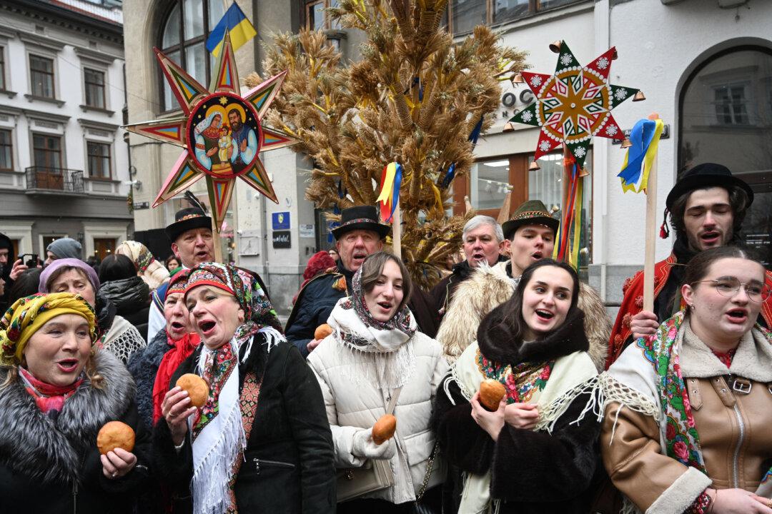 People wearing traditional clothes and carrying Ukrainian traditional “Didukh” Christmas decorations sing carols as they take part in a Christmas Eve procession in Lviv, Ukraine, on Dec. 24, 2025, amid the Russian invasion of Ukraine. (Yuriy Dyachyshyn/AFP via Getty Images)
