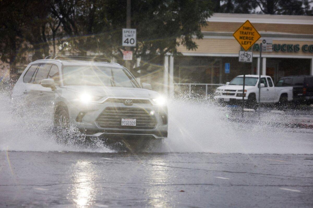 Cars drive through puddles as heavy rain falls due to an atmospheric river, in an intersection in the Woodland Hills area of Los Angeles, on Dec. 24, 2025. (Jill Connelly Reuters)