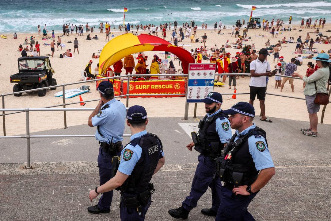 Police officers patrol near beachgoers on Christmas Day at Bondi Beach in Sydney, on Dec. 25, 2025. Father-and-son gunmen are accused of firing into crowds at a Jewish festival being held at Bondi Beach on Dec. 14, killing 15 in an attack authorities linked to the ideology of the ISIS terrorist group. (David Gray/AFP via Getty Images)