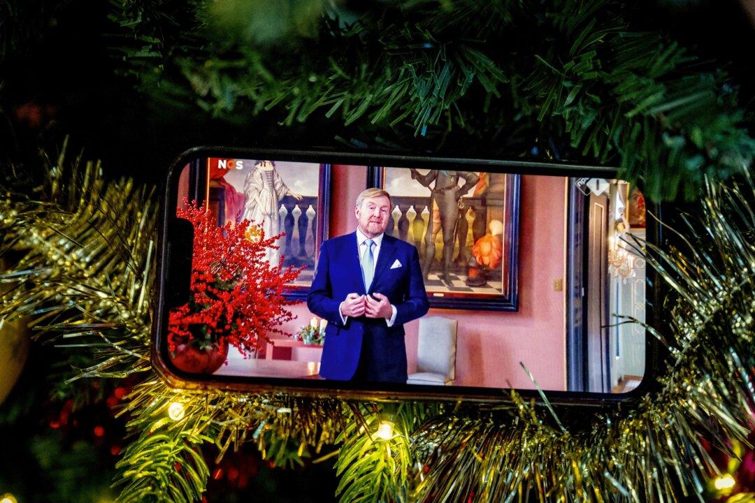 This photograph shows a smartphone displayed on a Christmas tree, with a livestream of Dutch King Willem-Alexander's annual Christmas speech, in Rotterdam, Netherlands, on Dec. 25, 2025. (Robin Utrecht/ANP/AFP via Getty Images)