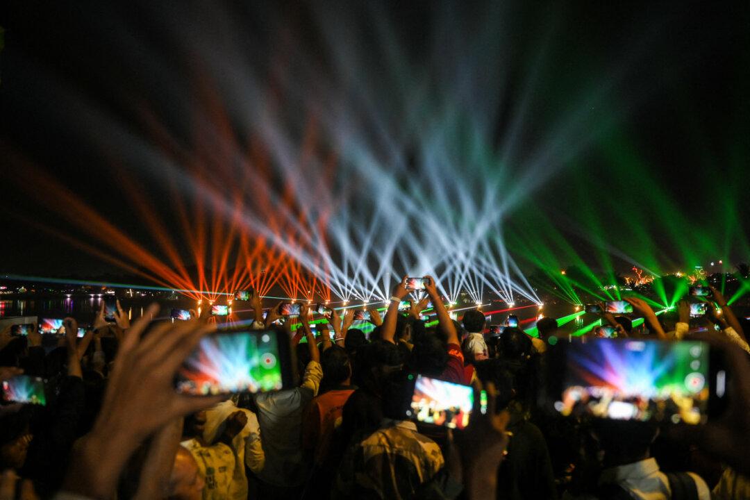 People use their mobile phones to capture a laser show during the inauguration of the Kankaria Carnival in Ahmedabad, India, on Dec. 25, 2025. (Shammi Mehra/AFP via Getty Images)