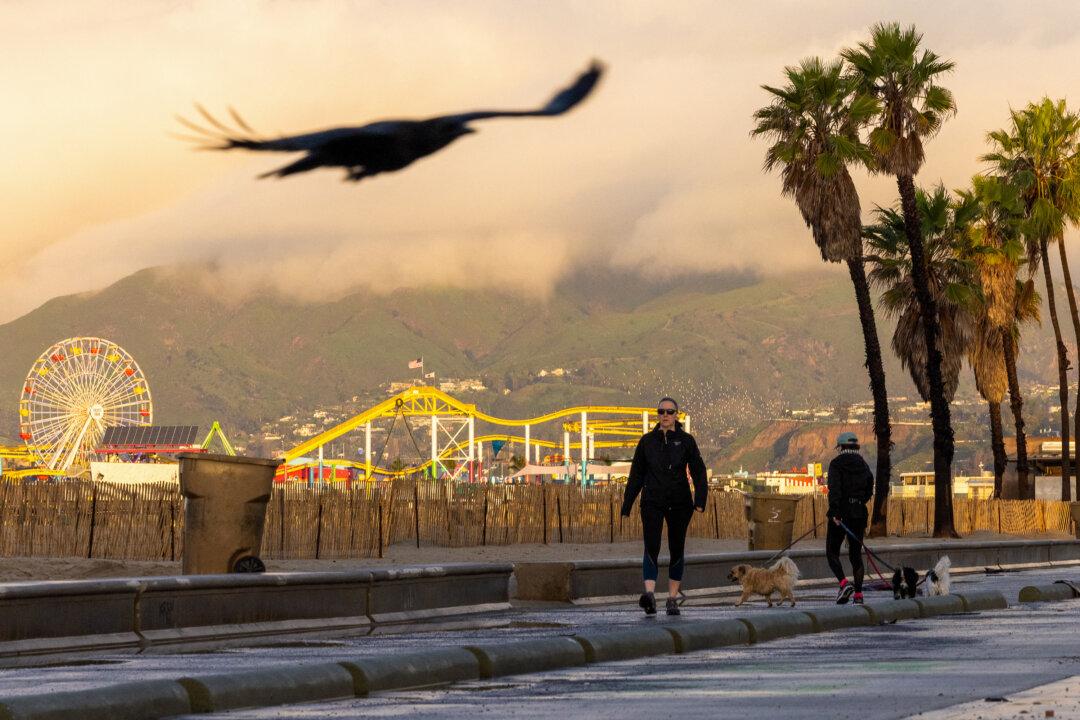 People walk on a bike path during a break from the rain storms impacting Southern California, in Santa Monica, Calif., on Dec. 25, 2025. (Robyn Beck/AFP via Getty Images)