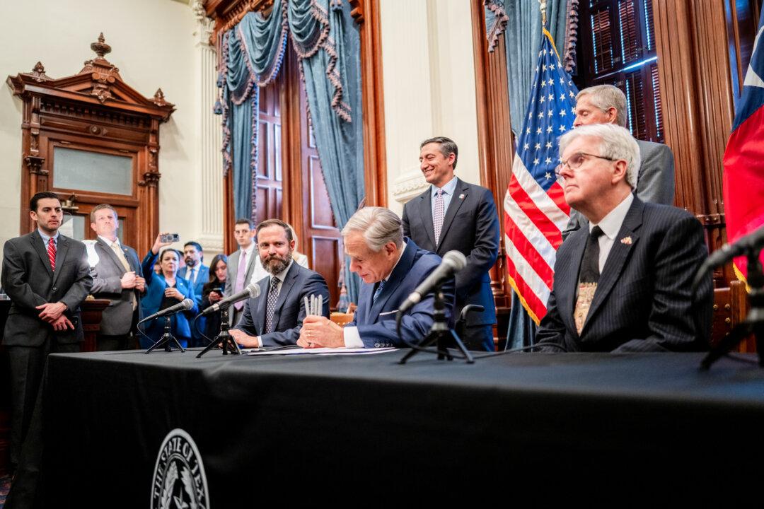 Texas Gov. Greg Abbott signs a bill at the Texas Capitol in Austin on April 23, 2025. In 2025, Abbott, citing the EPIC project, signed measures that would curb exclusionary residential compounds and restrict land purchases by foreign adversaries and transnational criminal groups. (Brandon Bell/Getty Images)